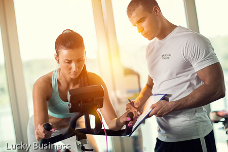 Personal trainers in the gym giving instruction and help to attractive young women