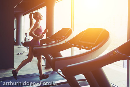 Fitness girl running on treadmill