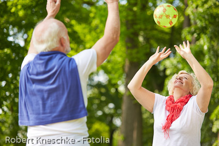 Alte Frau und Senior spielen Ball im Park