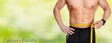 Man abdomen with measuring tape over blue background.