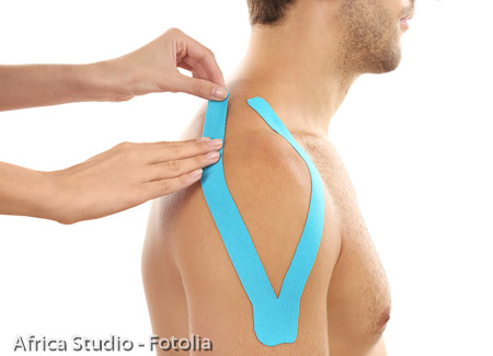 Female hands applying physio tape onto patient shoulder, isolated on white