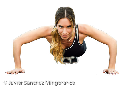 Young beautiful woman doin pushups in the gym. 