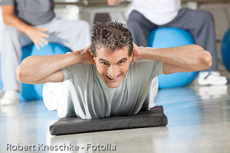 Mann macht Rückenübung im Fitnesscenter