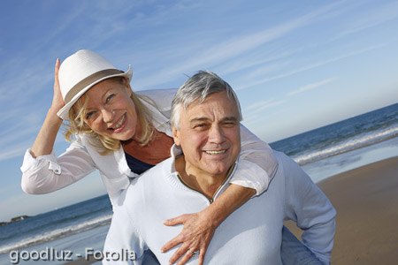 Portrait of cheerful senior couple having fun at the beach