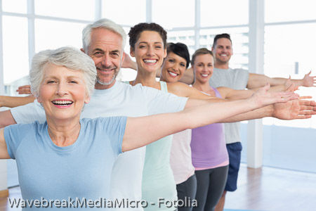 Portrait of fitness class stretching hands in row