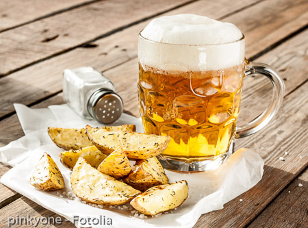 Beer mug and potato wedges on wood table
