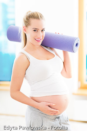 Pregnant woman holding yoga mat