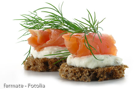 two  salmon canapes with fresh dill garnish, isolated on white b