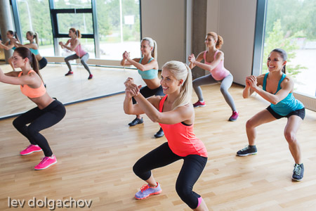 group of women making squats in gym