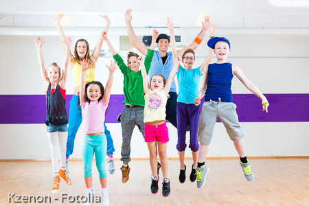 Dance teacher giving kids Zumba fitness class 