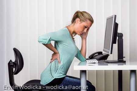 Frau mit Rückenschmerzen im Büro