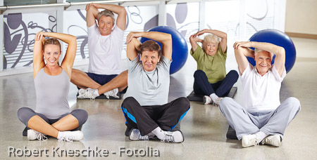 Gruppe Senioren beim Dehnen im Fitnesscenter