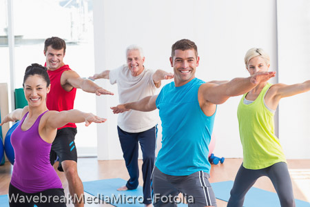 People doing warrior pose in yoga class