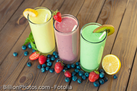 Antioxidant. Fresh milk, strawberry, blueberry and banana drinks on wodeen table, assorted protein cocktails with fresh fruits.