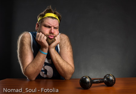 Sad man with a dumbbell