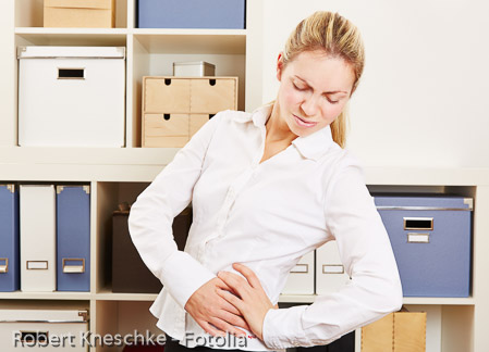 Frau im Büro hat Rückenschmerzen
