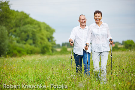 Frau und Mann wandern über Feld im Sommer