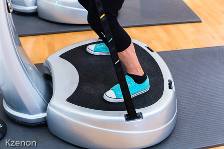Woman on vibrating plates in gym training
