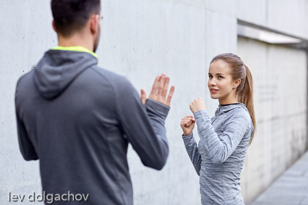 happy woman with coach working out strike outdoors